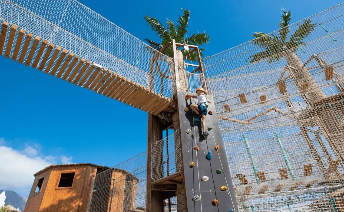 a child climbs a climbing wall in a playground
