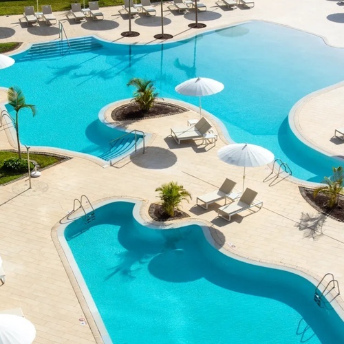 una vista aérea de una piscina con sillas y sombrillas