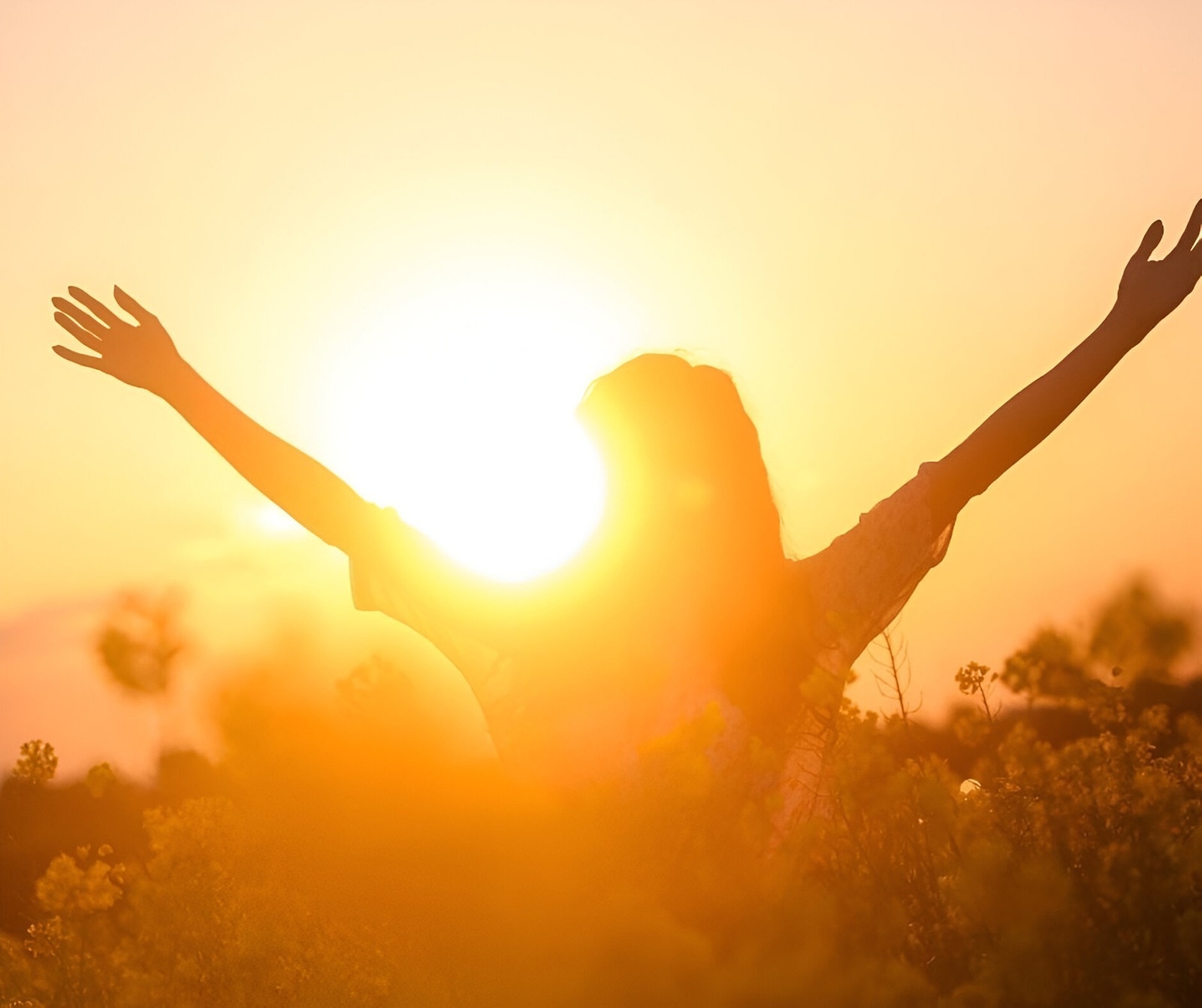 a woman with her arms outstretched in front of the sun