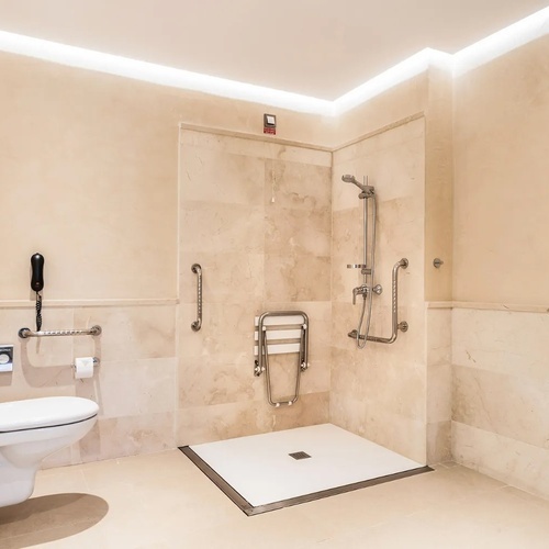un baño con inodoro y ducha para personas con discapacidad