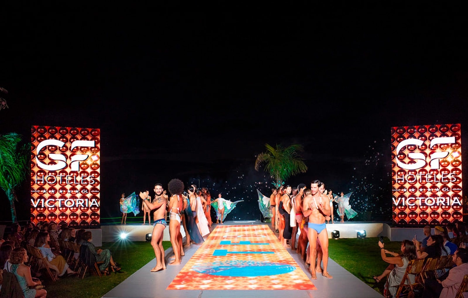 un grupo de modelos camina por la pasarela en un desfile de moda