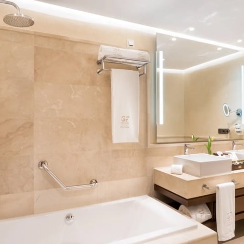 un baño de hotel con dos lavabos y una bañera