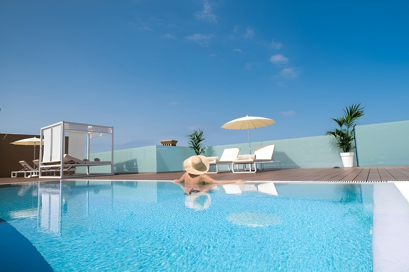 a woman in a hat sits in a swimming pool