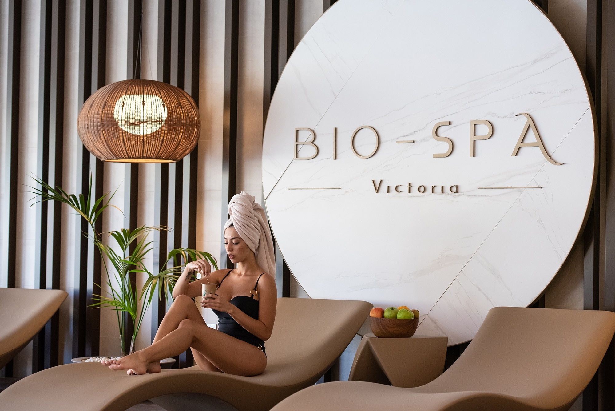 a woman sits in a chair in front of a sign that says bio-spa victoria