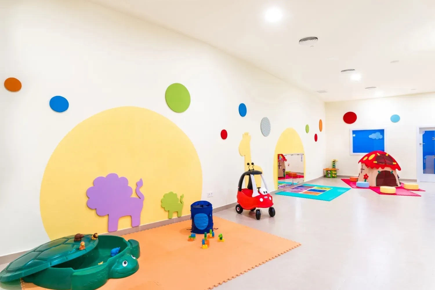 una sala de juegos para niños con juguetes y paredes pintadas de colores