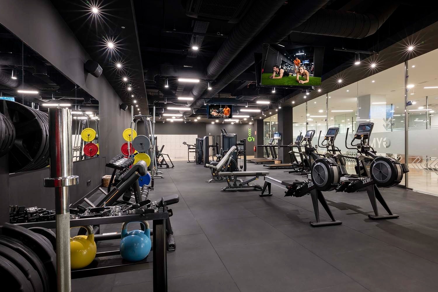 un gimnasio con muchos aparatos y una pantalla que dice nyr
