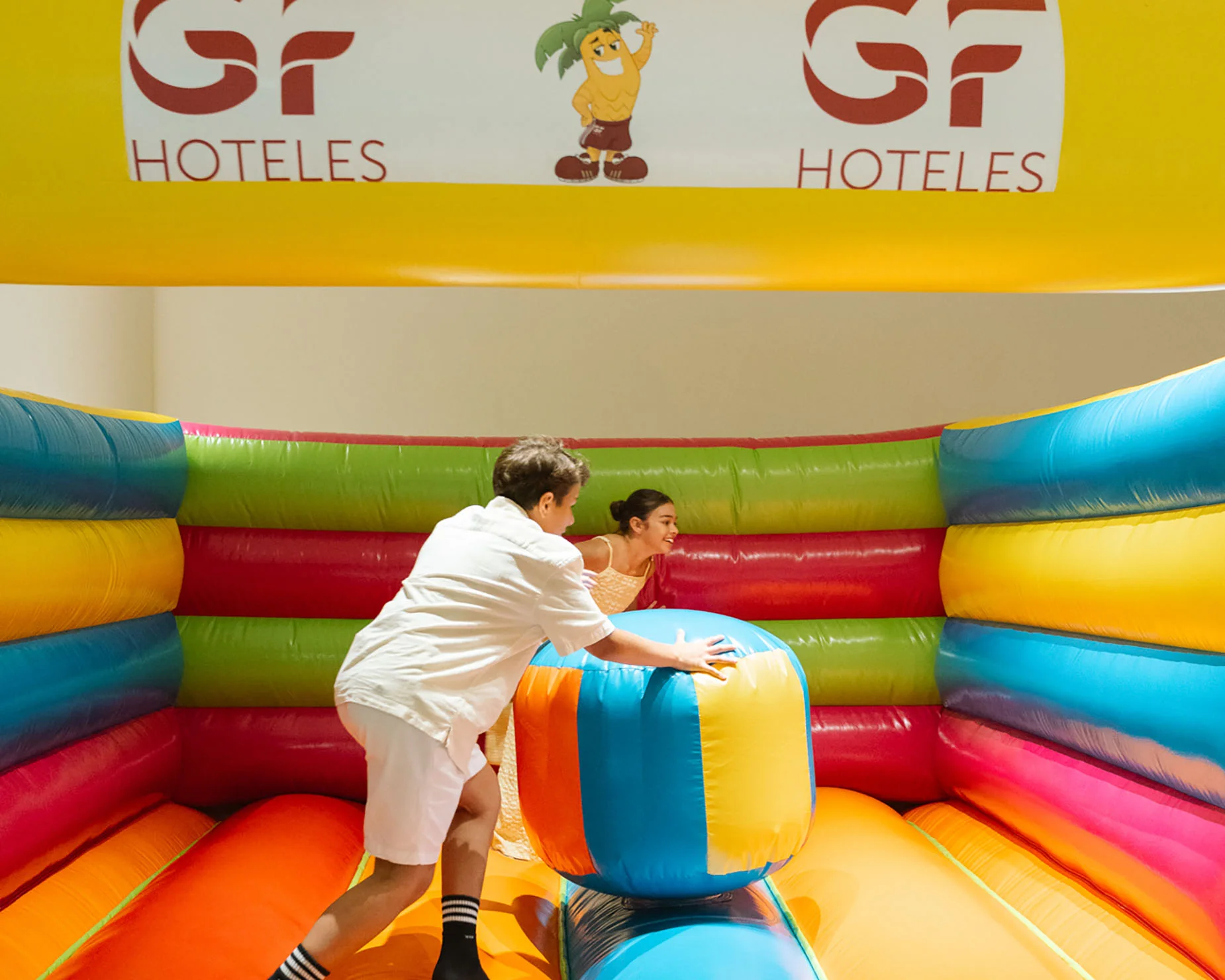 Niños jugando air hockey en GF: Victoria con luces de neón.