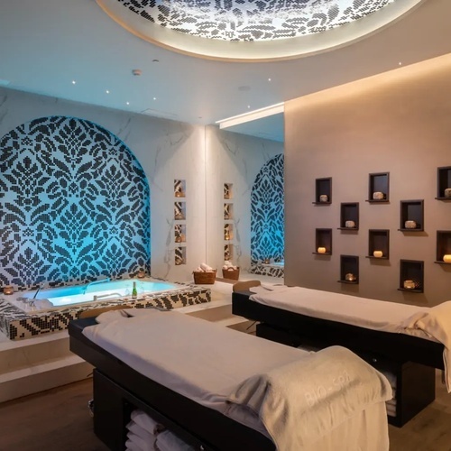 una habitación de spa con dos camas y una bañera