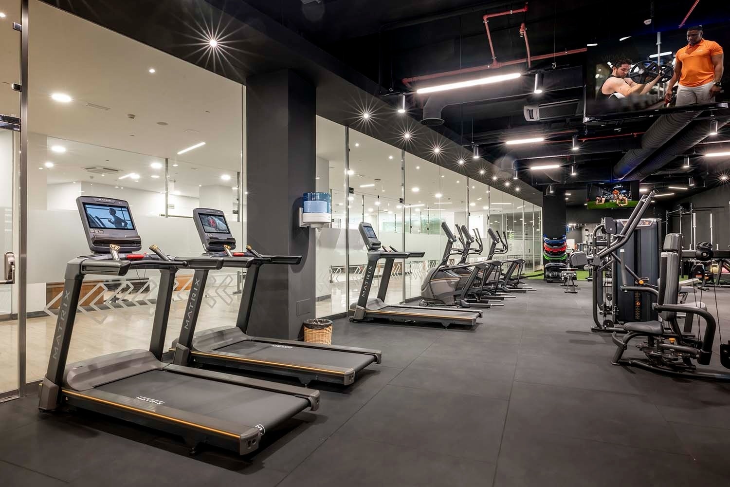 una fila de cintas de correr marca matrix en un gimnasio