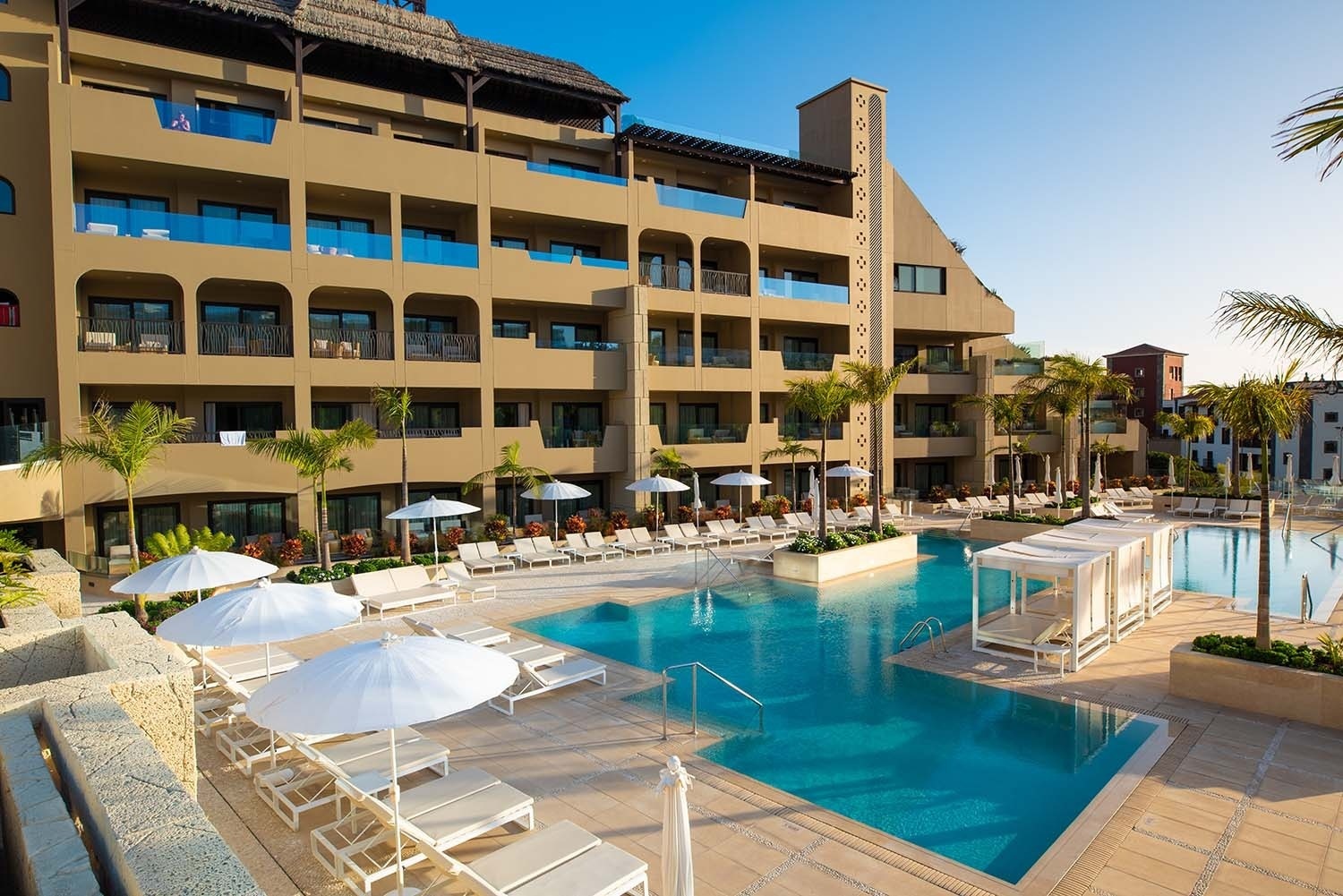 a woman in a black bikini is swimming in an infinity pool
