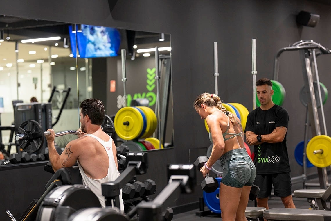 un hombre y una mujer están haciendo ejercicio en un gimnasio