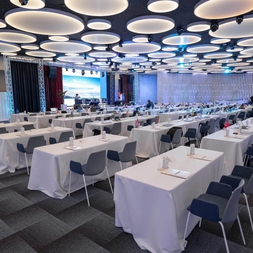 una sala de conferencias llena de mesas y sillas