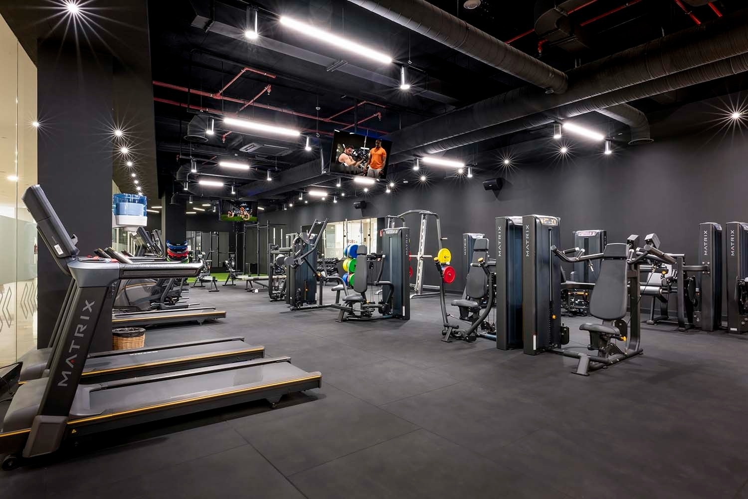 un gimnasio con muchas máquinas y una cinta de correr que dice matrix