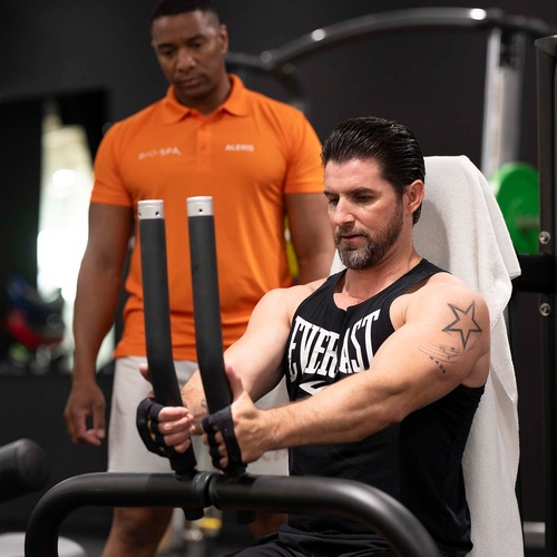 un hombre con una camiseta de everlast está haciendo ejercicio en un gimnasio