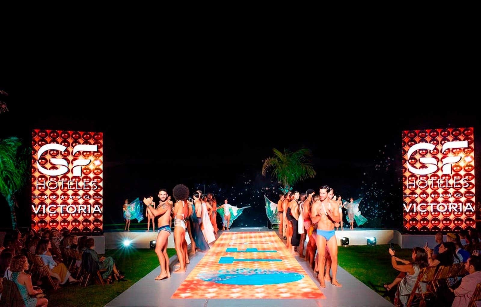 a beach at sunset with buildings in the background