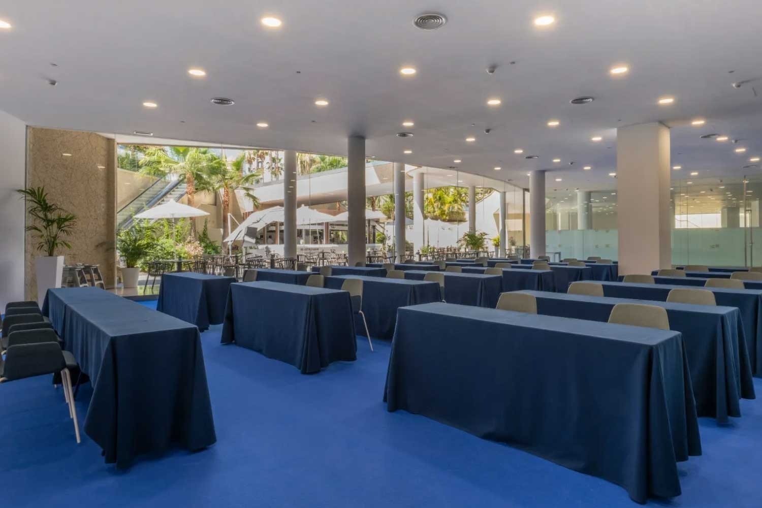 una sala de conferencias llena de mesas y sillas