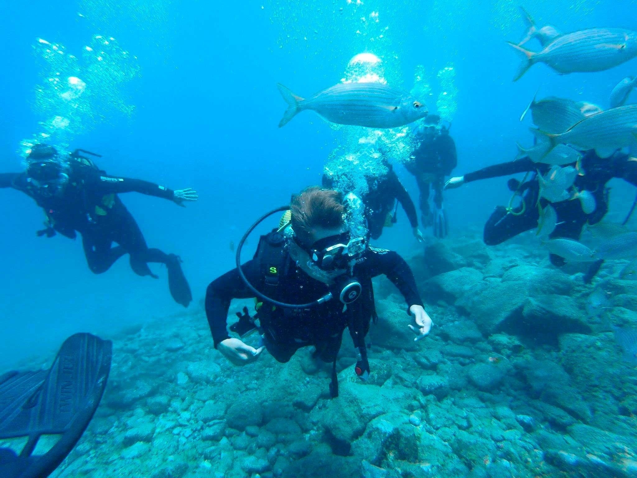 un grupo de hombres y mujeres en vestidos blancos con lunares rojos están actuando en un escenario