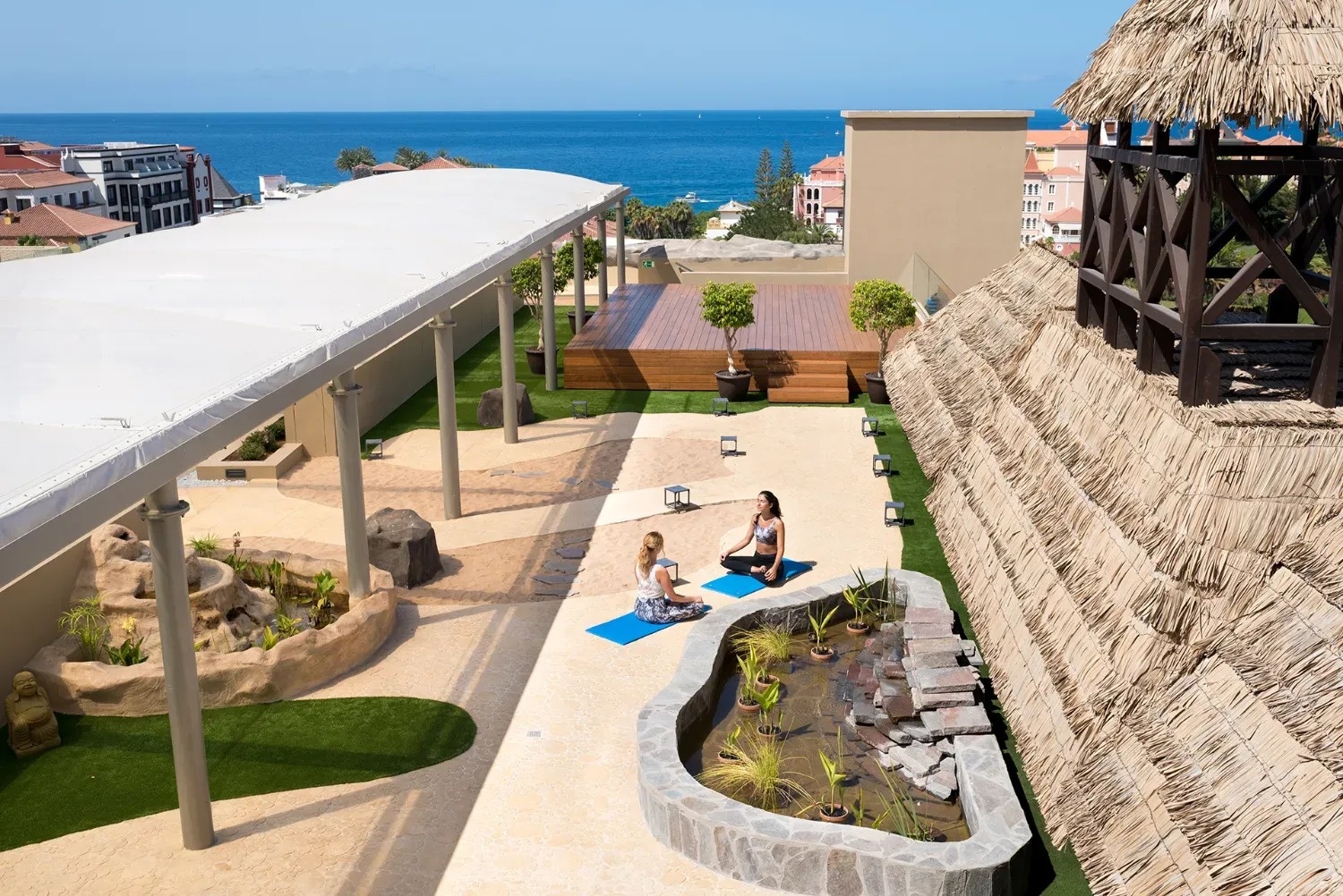 dos mujeres están practicando yoga en un patio al aire libre