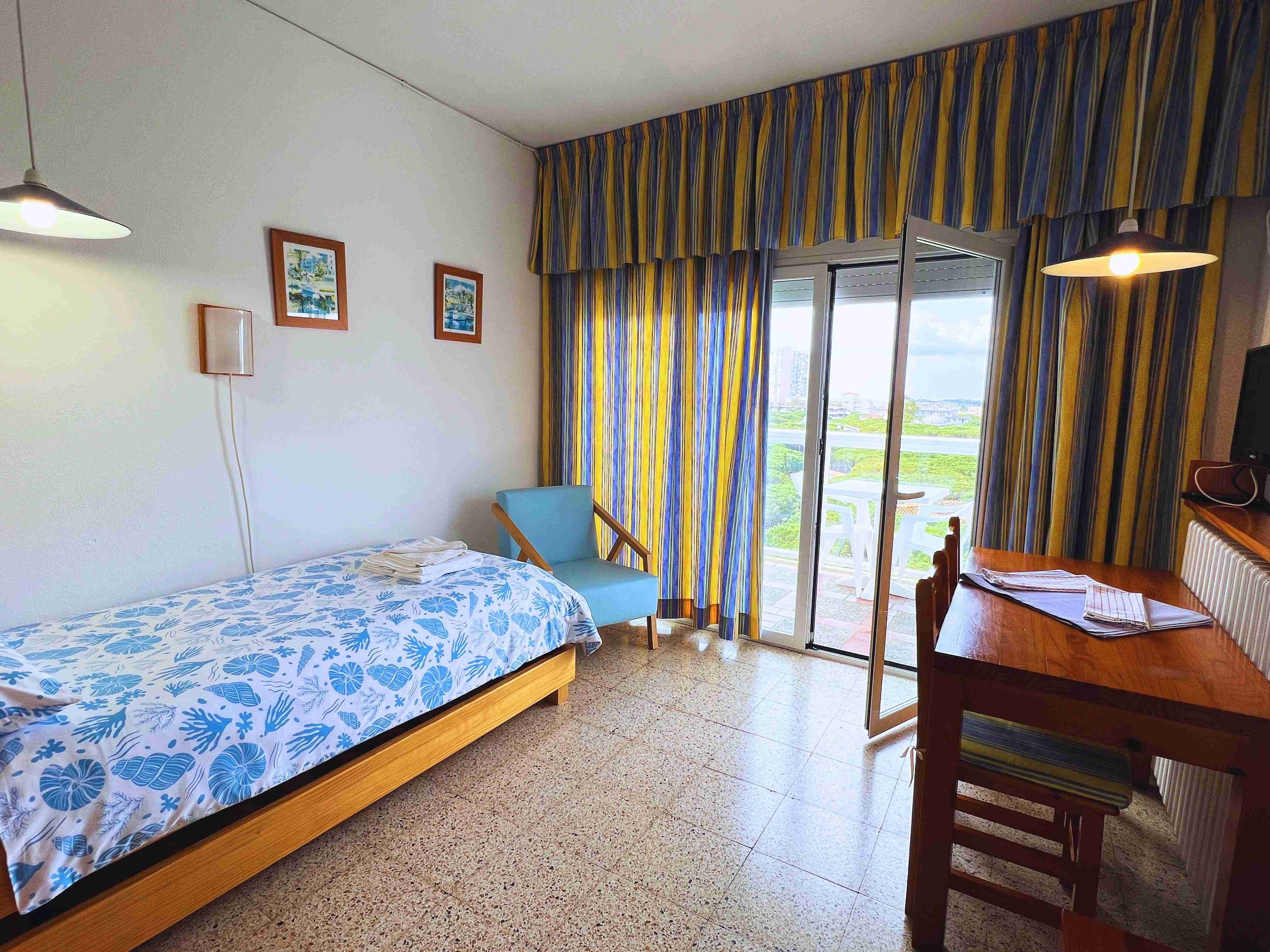 una habitación con una cama , una silla y una mesa