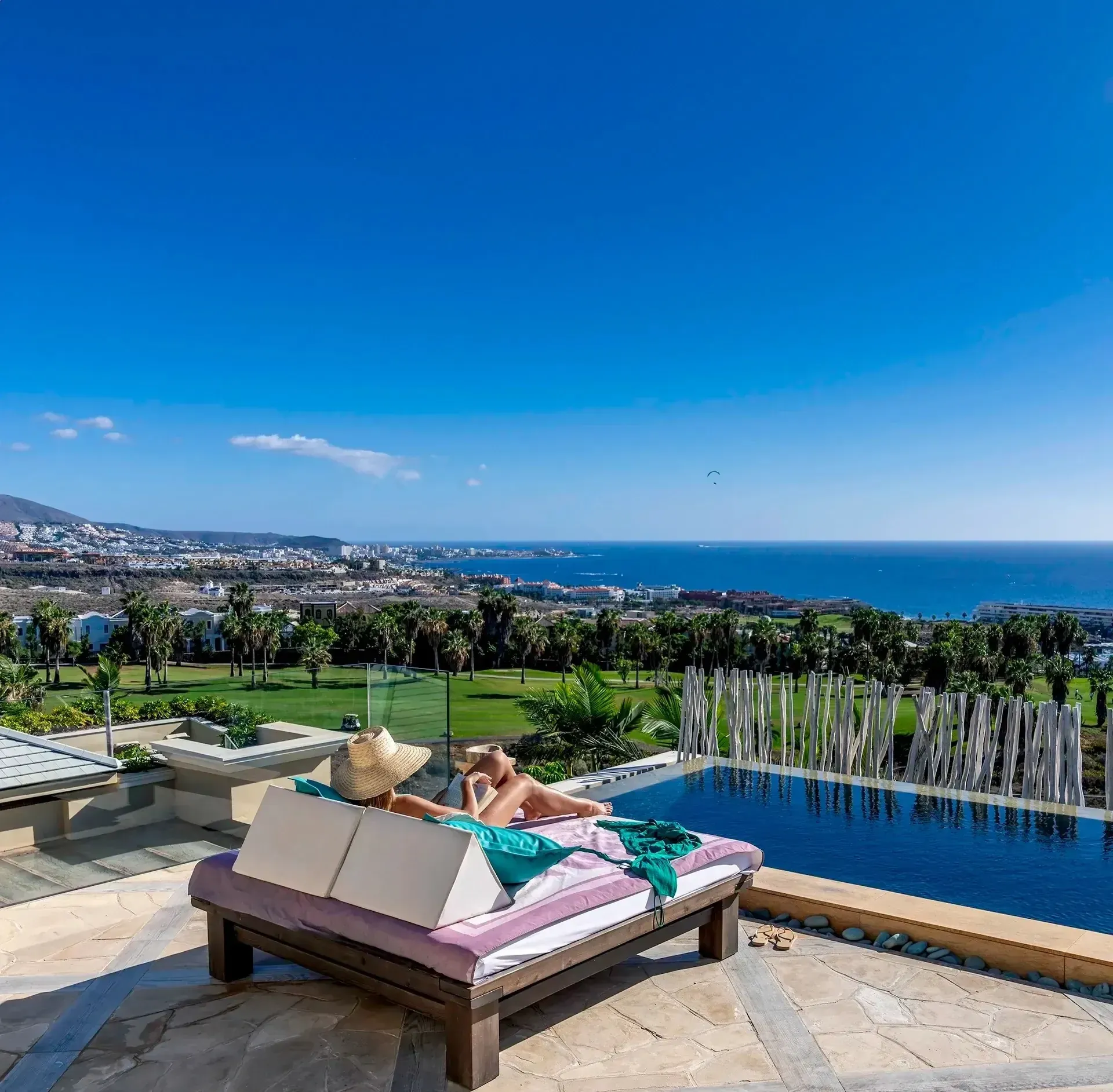 Femme profitant du soleil sur une chaise longue devant l'océan, Villas de vacances | Hôtel de luxe Royal River ***** | Ténérife.