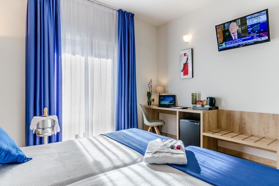 una habitación de hotel con dos camas y una televisión