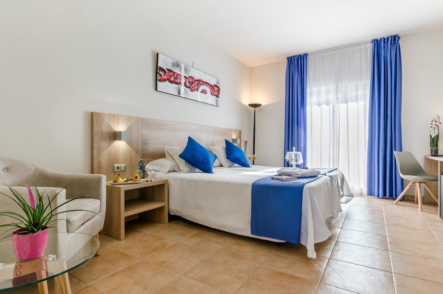 una habitación de hotel con una cama y cortinas azules