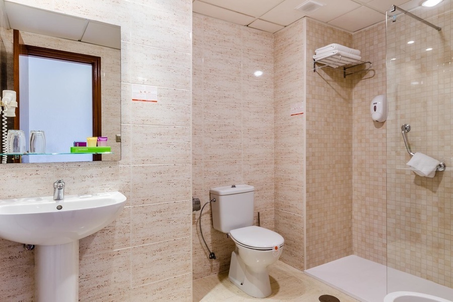 un baño con inodoro , lavabo y ducha