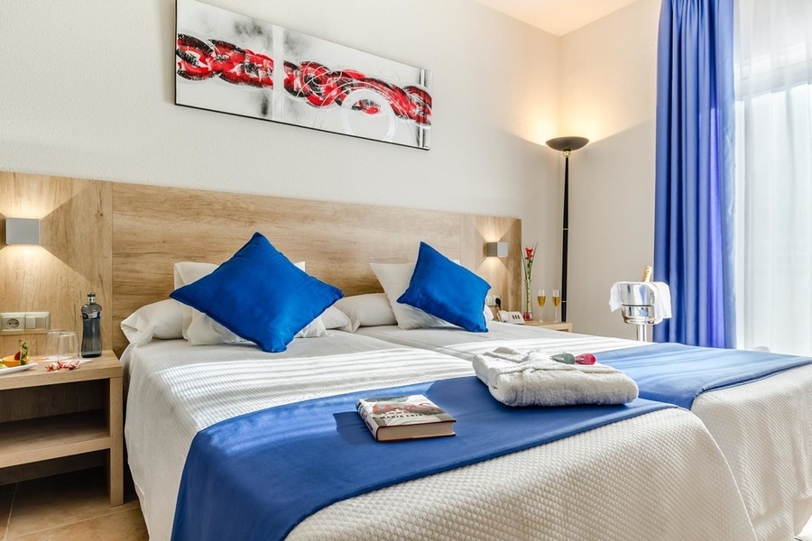 una habitación de hotel con dos camas y una pintura en la pared
