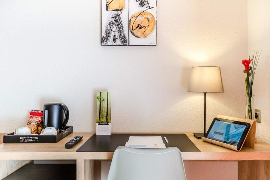 un escritorio en una habitación de hotel con una caja de nescafe