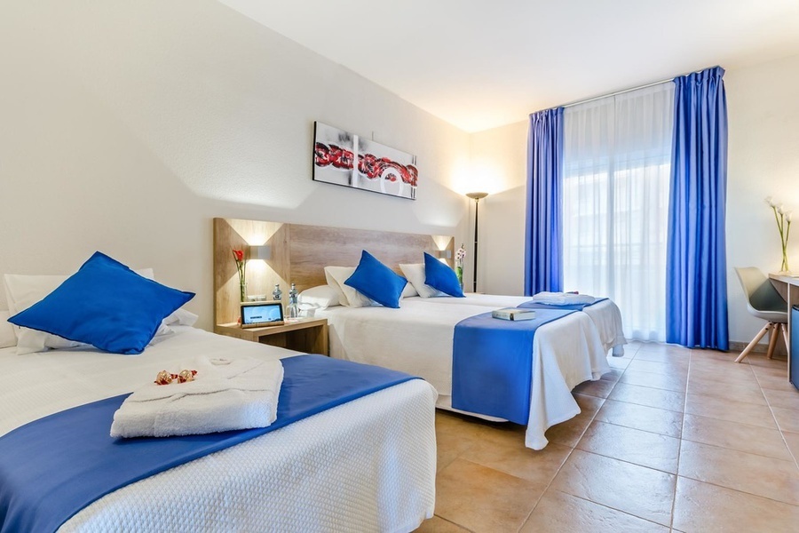 una habitación de hotel con dos camas y cortinas azules