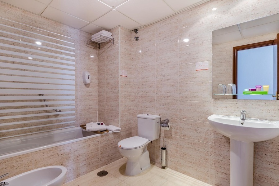 un baño con inodoro , lavabo y bañera