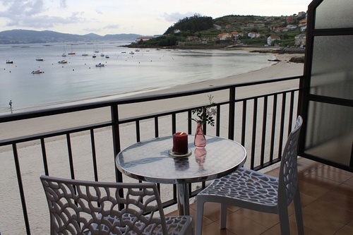 a candle sits on a table on a balcony overlooking the ocean