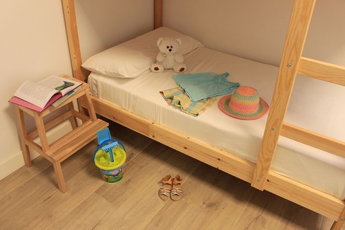a bunk bed with clothes and a teddy bear on it