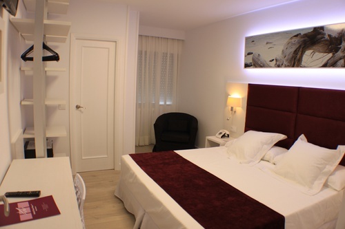 a hotel room with a bed and a chair