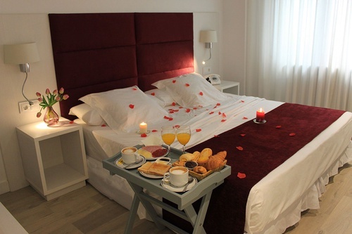 a bed with a tray of food and drinks on it