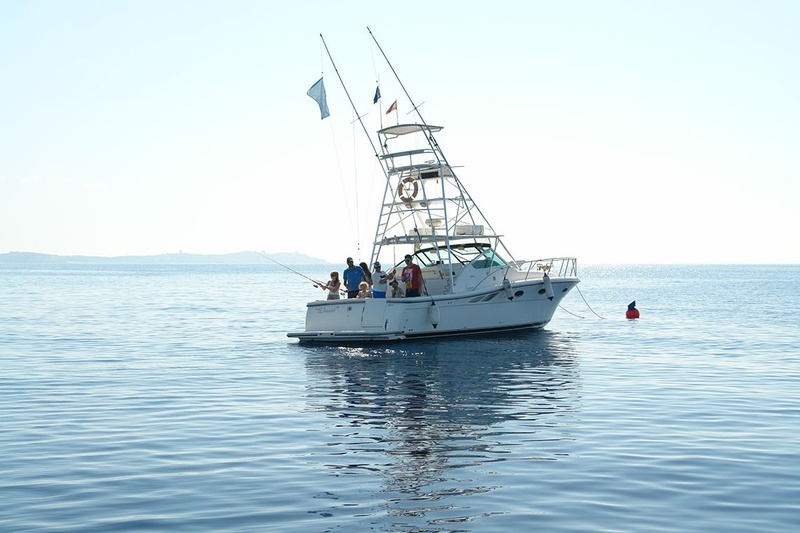 un grupo de personas pescando en un barco en el océano
