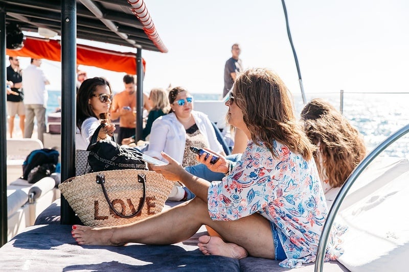 una mujer se sienta en un barco con una bolsa de mimbre que dice love