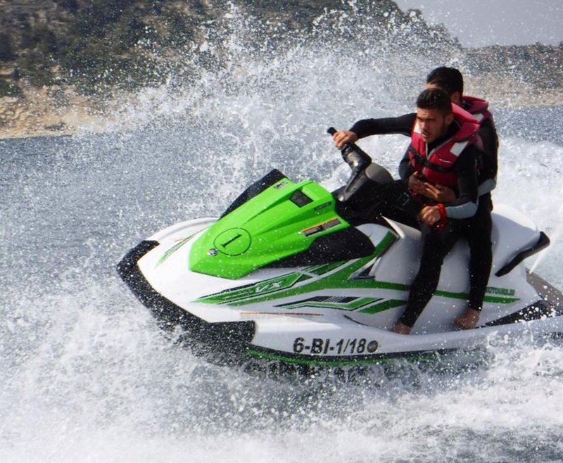 dos hombres montan un jet ski verde y blanco con la matrícula 6-bi-1-180
