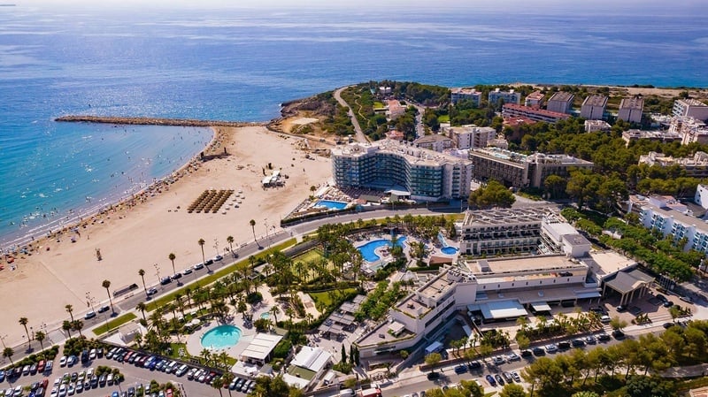 an aerial view of a beach resort with a large building in the middle