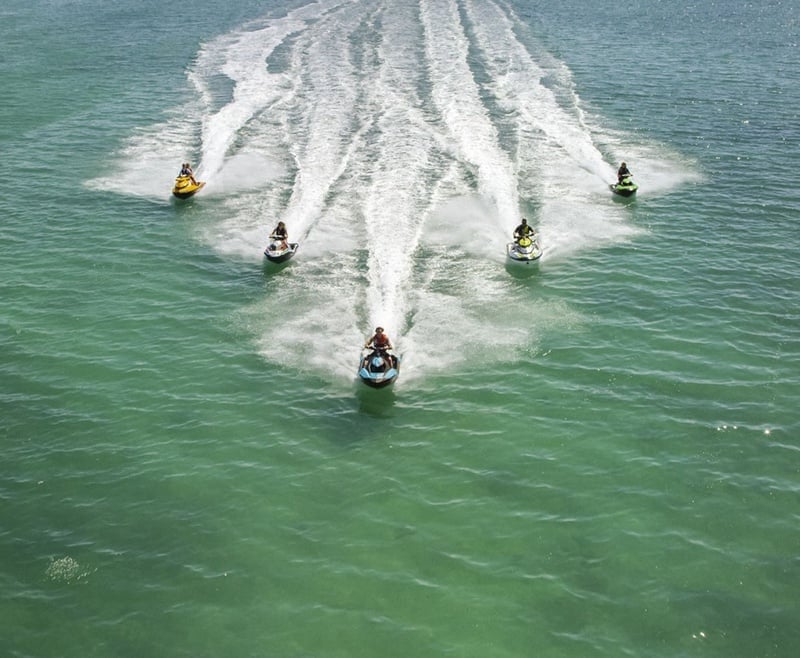 un grupo de personas en jet ski en el océano