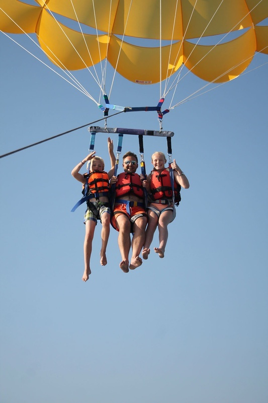 un grupo de personas está volando en un paracaídas amarillo
