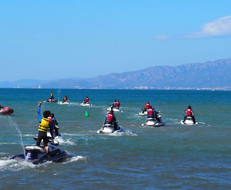 un grupo de personas montan jet ski en el océano