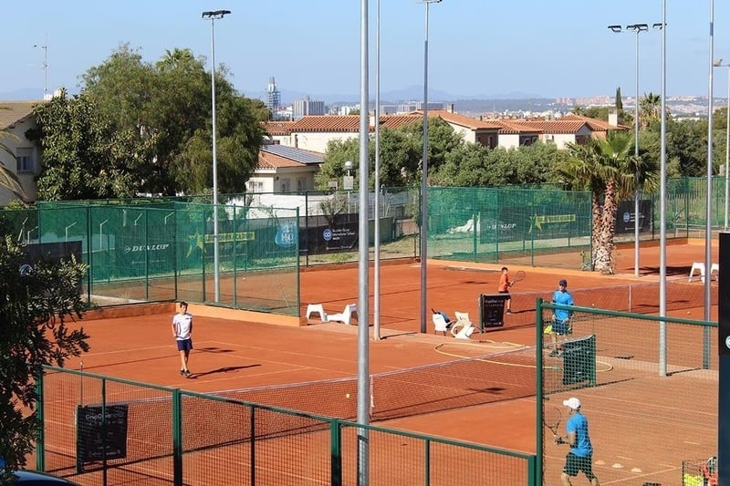alguns jugadors de tenis en una pista de tenis amb un cartell de dunlop