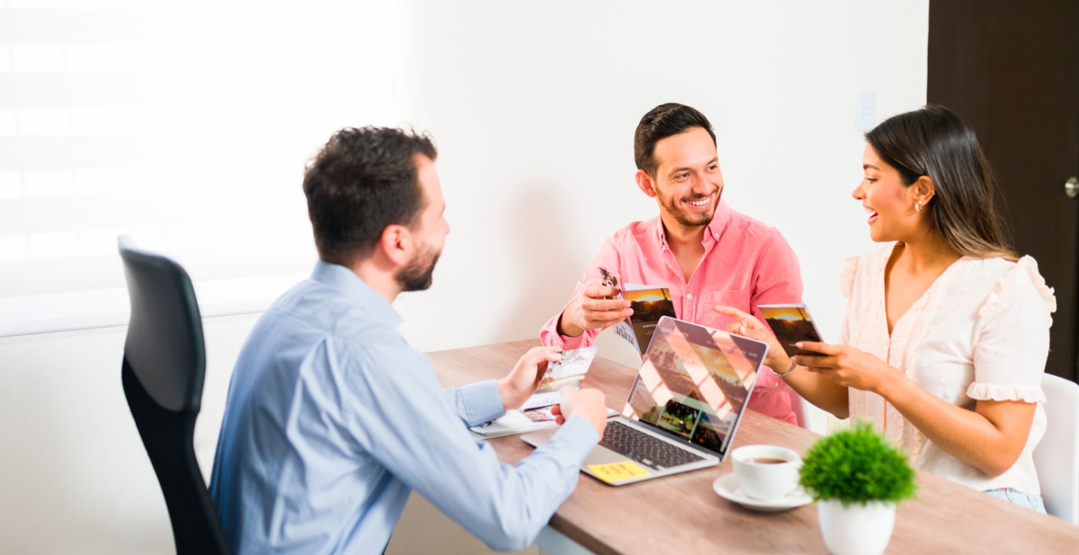 un grup de persones està conversant a una mesa amb un lap top