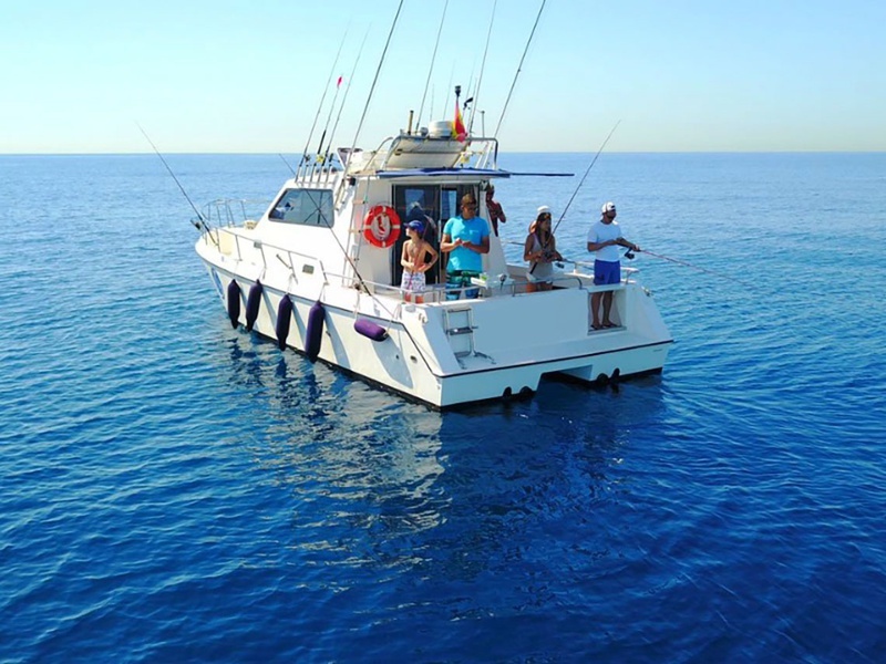 un grupo de personas pescando en un barco en el océano