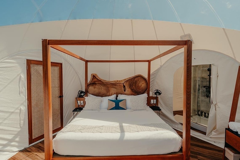 a bed in a tent with a wooden headboard