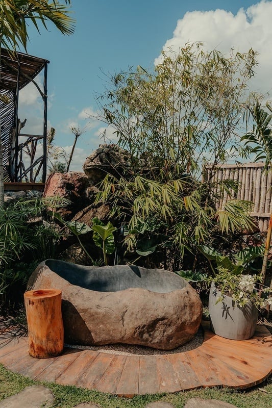 a large rock in the middle of a garden