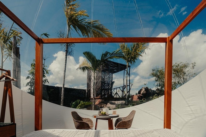 a canopy bed with a table and chairs underneath it