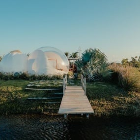 a white house with a wooden bridge leading to it