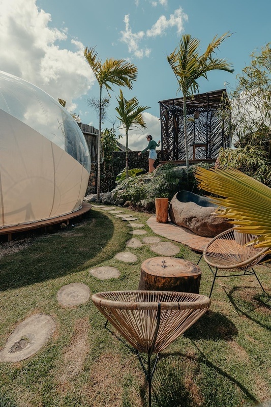 a woman stands in front of a bubble tent